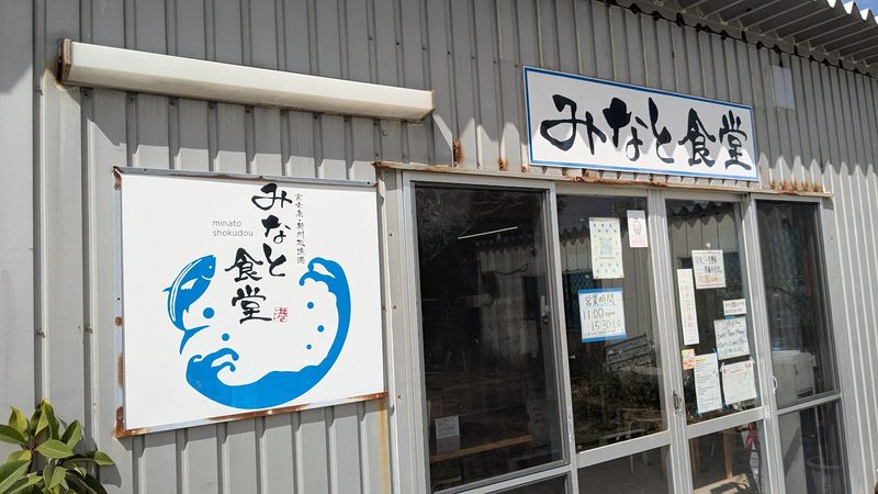 壁に掲げた「みなと食堂」の看板と魚のロゴ